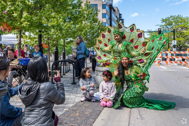 Take a photo with the women in peacock dresses at the Downtown Evanston Umbrella Arts Festival.