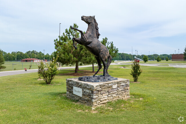A rearing Mustang bronze statue adorns the lawn at Center Hill High School.