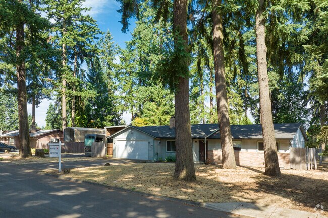 Towering pines shade ranch homes in Image, creating a serene forest vibe.