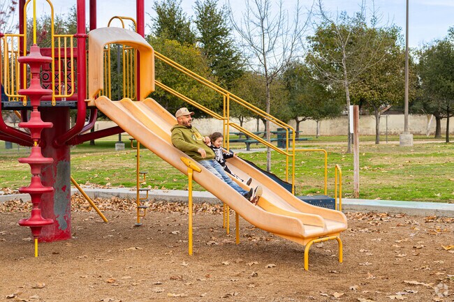 An East Delano father races his daughter downt the slide at Morningstar Park.