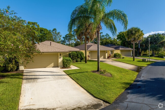 Mature palm trees and pristine landscaping enhance a row of Sugar Mill homes.
