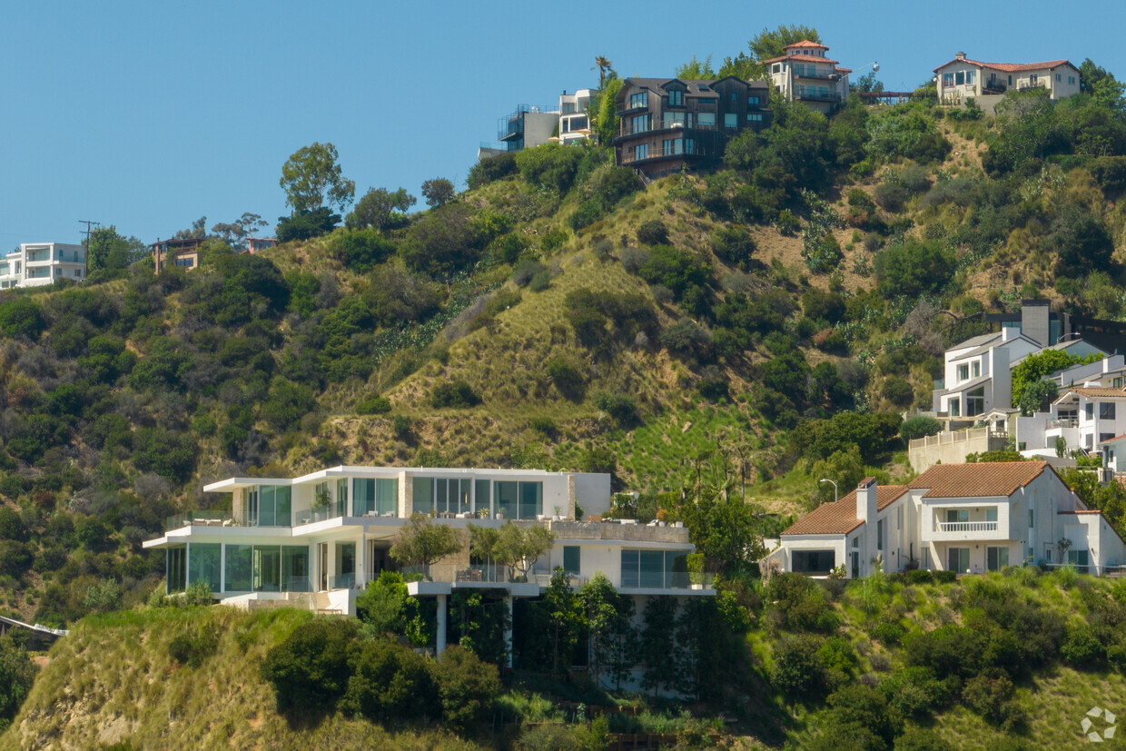 hillside house on stilts by TWO+ preserves natural surroundings