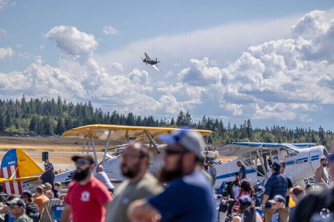 Spectators look on as the P-47 Thunderbolt fly by at the Bremerton Air Show in Gorst WA.