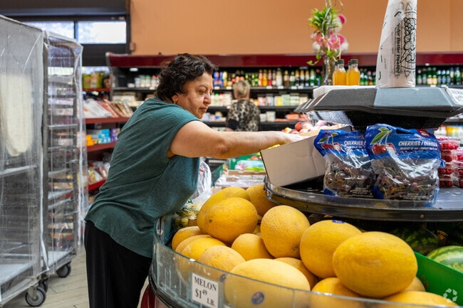 Shoppers browse fresh produce at Maple Market, filling their baskets with seasonal fruits and vegetables.