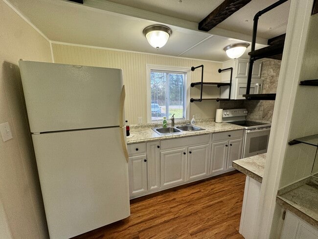 Galley kitchen with new cabinets and shelving.