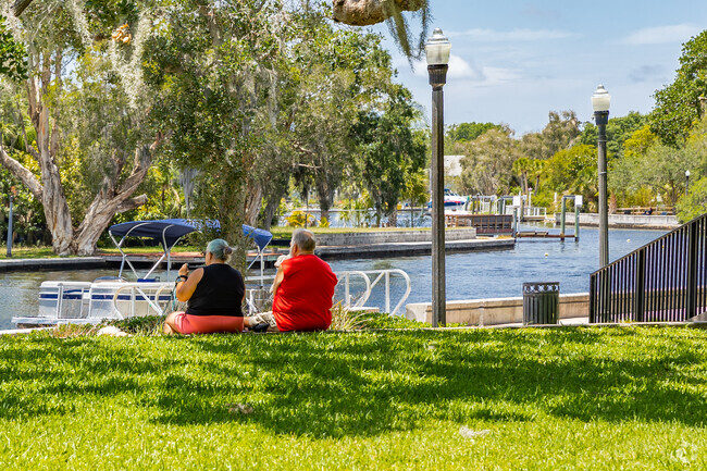 A couple relaxes as they watch boats go by on the Cotee river in Downtown New Port Richey.