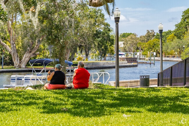 A couple relaxes as they watch boats go by on the Cotee River in Downtown New Port Richey.