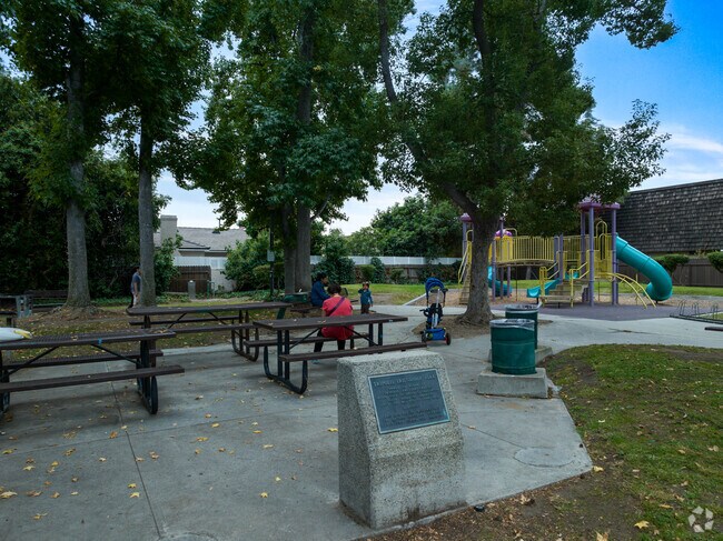 A shaded picnic area overlooks the playground at Tripolis Friendship Park.