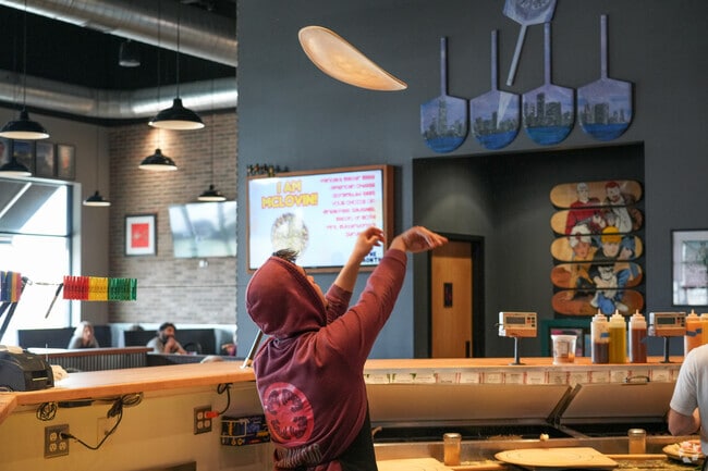 Tomato Bar is a locally owned pizza shop where the cooks make a show out of preparing pizzas.