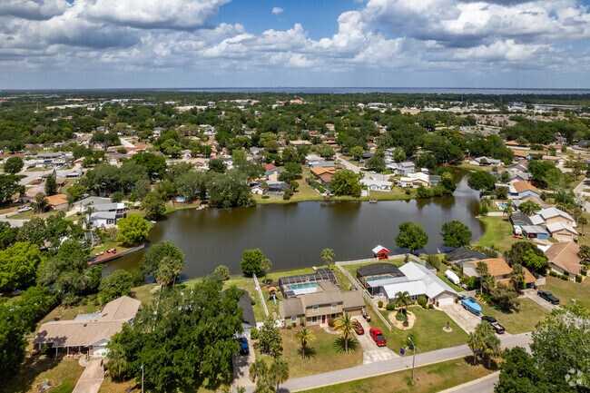 At Pine Lake Estates' center is a lake with docks and piers behind some homes.