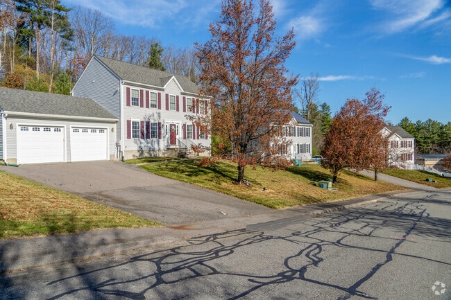 A row of colonial revival style homes in West Fitchburg have attached garages.