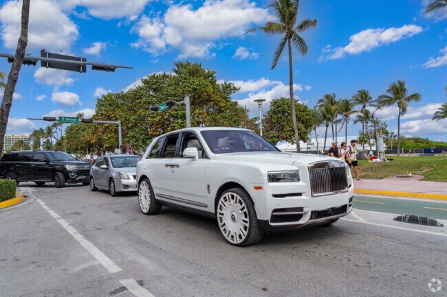 High end luxury vehicles line Ocean Drive the heart of the beautiful Lummus Park.