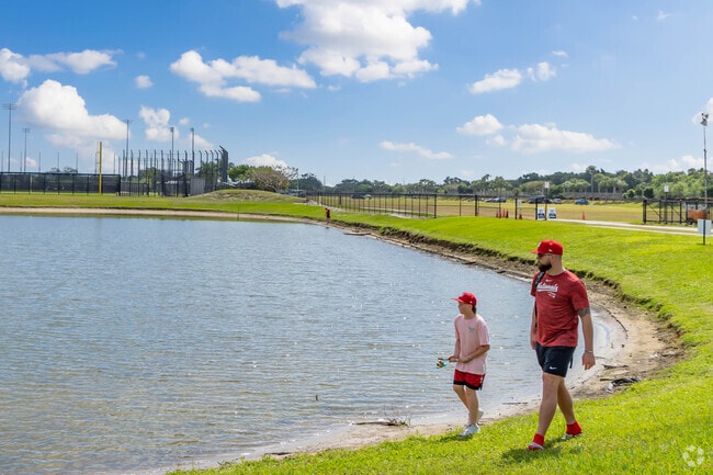 A father and son fishing along a serene lake in Palm Beach Lakes.