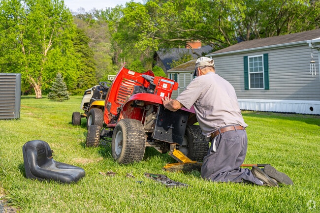 A Perryman resident fixes his lawn mower as he gets ready to cut the grass.