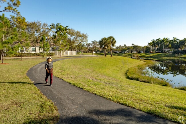 A woman takes a morning stroll along a lake in the Indian Spring neighborhood of Golf, FL.