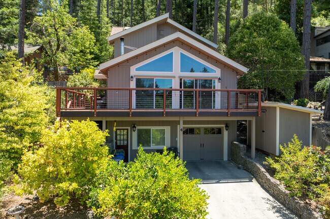 Elevated above the trees, this Felton contemporary home features a broad deck, modern exterior, and oversized windows that capture the quiet beauty of redwood living.