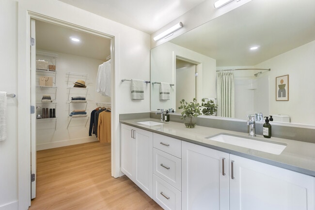 Renovated Package I bath with white cabinetry, grey quartz countertops and hard surface flooring