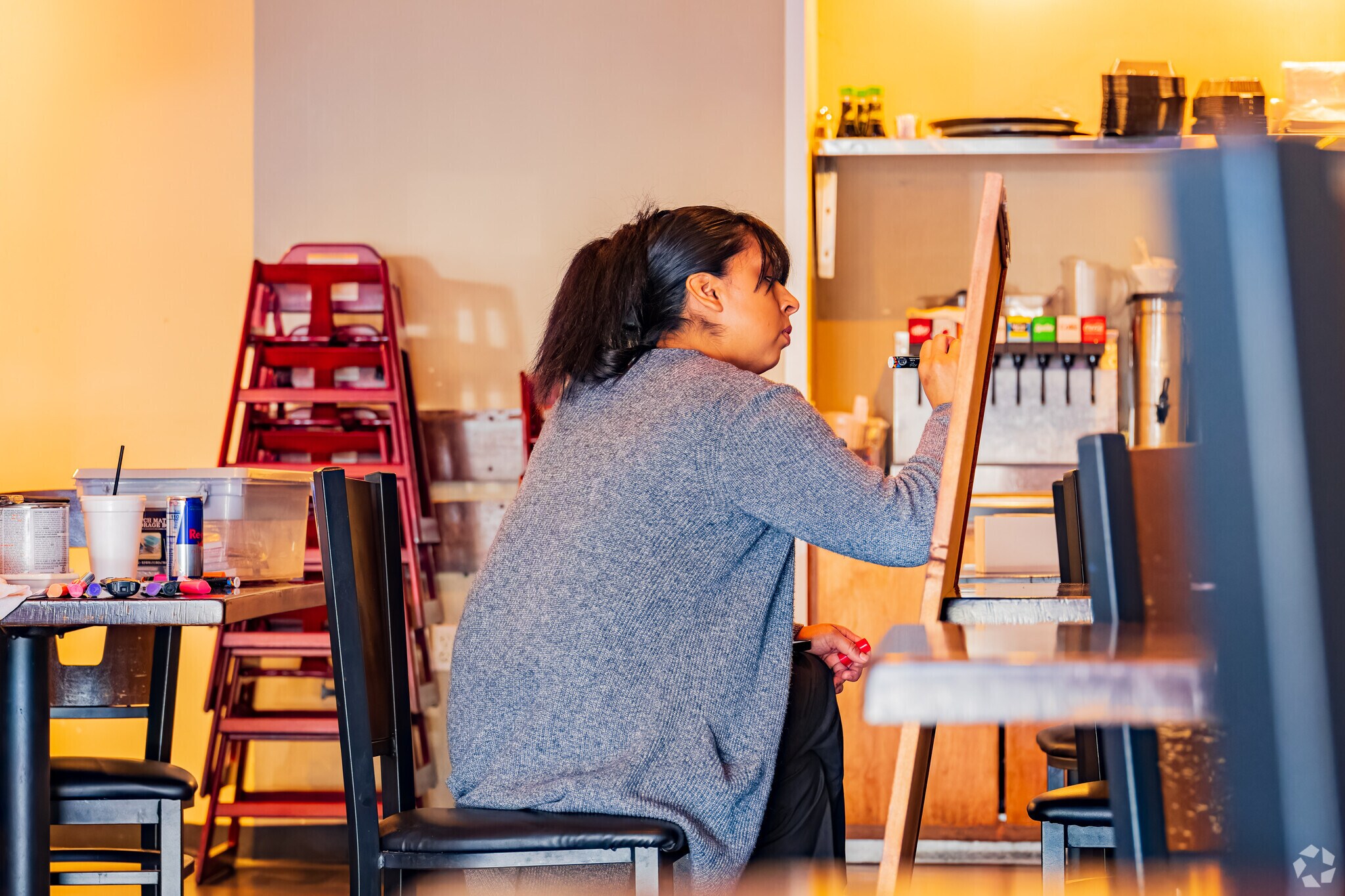 Woman painting for restaurant near Twin Oaks.