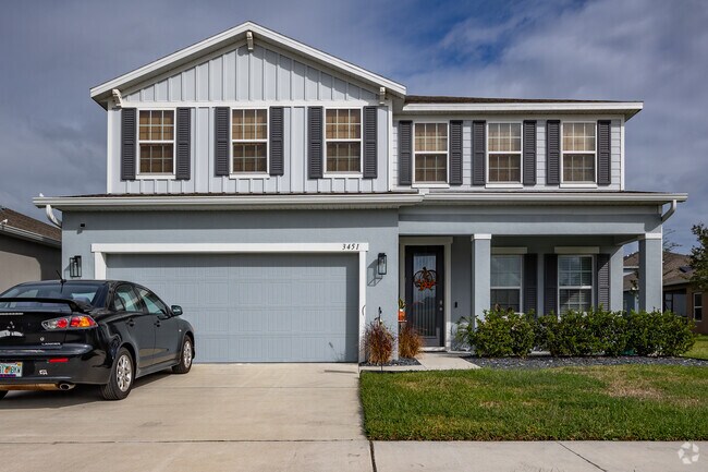This two-story new construction home boasts a beautiful blue exterior and tidy landscaping.