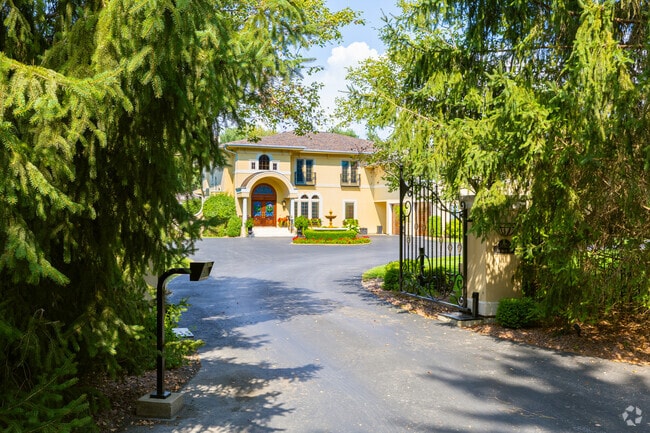 Private driveways extend from the surrounding roads of Oconomowoc Lake, leading to expansive estates discreetly situated within wooded areas.