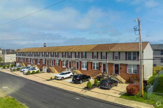 Fenced backyards and shared drives appear behind many rowhomes.