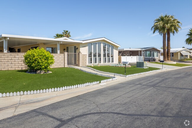 A serene row of manufactured homes within Palm Desert Greens Country Club, blending comfort and style with breathtaking desert views and a relaxed, community-driven lifestyle.