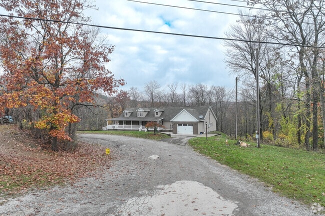 A long Cape Cod house set back from a driveway in Kittanning Township.