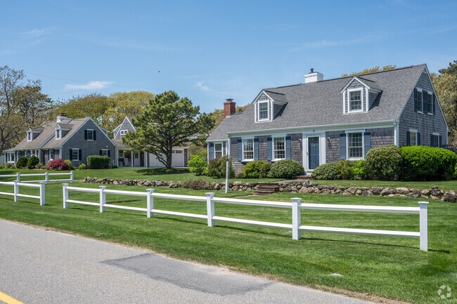 Two Cape homes stand shoulder to shoulder along a quiet street in Northwest Harwich.
