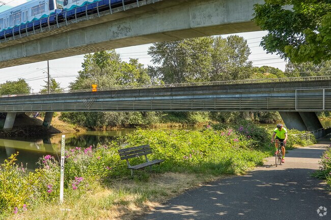 A biker rides under the Lightrail on the Green River trail in the Allentown neighborhood.