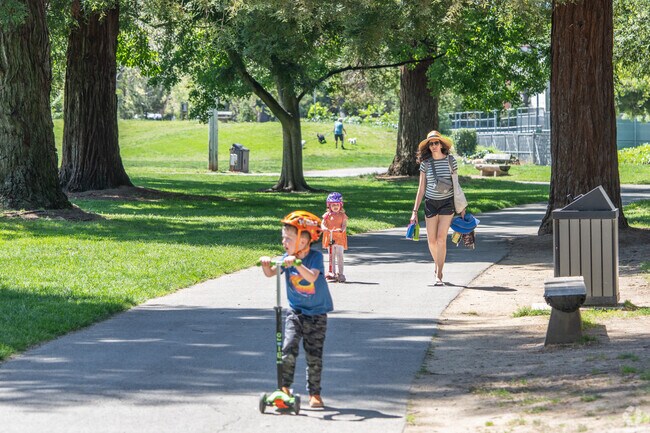 A mom walks through Cuesta Park with her children on the way to the play structure.