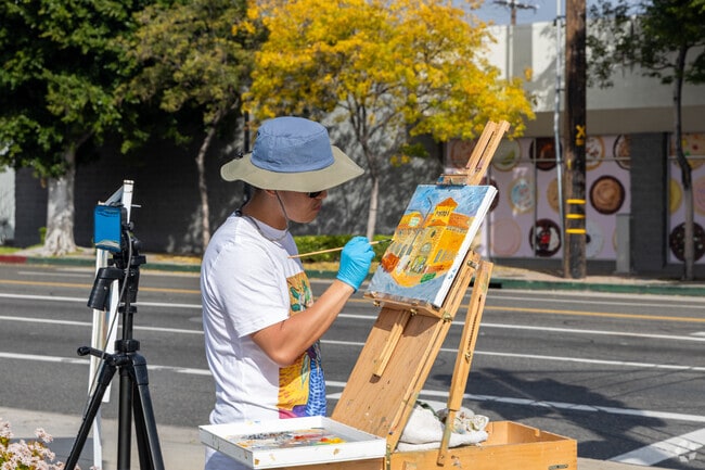 A painter recreates the entrance to Porto's on canvas in Chandler Park.