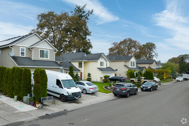 Contemporary homes with large trees in the back yard run along NE 87th Ave in Orchards-Area.