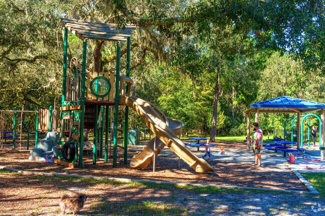A young Sugarfoot family enjoys the shaded playground at Green Acre Park.