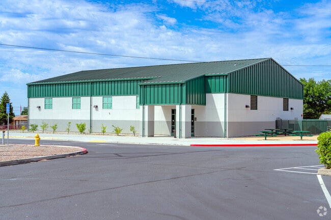The green roof of Columbia Elementary School matches the picnic tables.