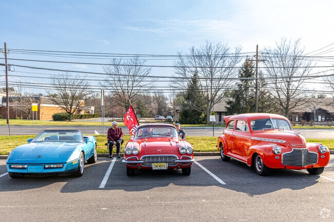 Three gentlemen showcase their classic cars at Foxmoor Shopping Center parking lot.