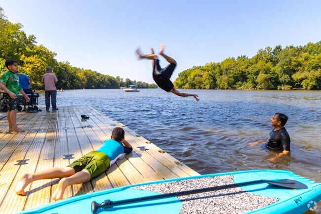 Children at Midlothian-Robious Landing Park enjoying jumping into the water and watersports.