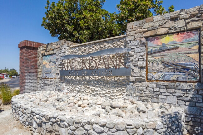 A stonework sign welcomes visitors to Riverbank.