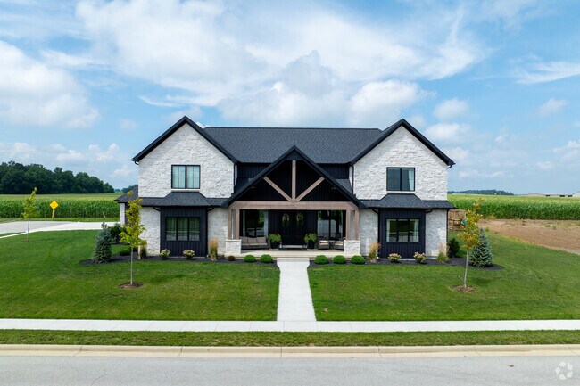 New Coldwater homes blend brick and siding near cornfields in a growing suburban area.