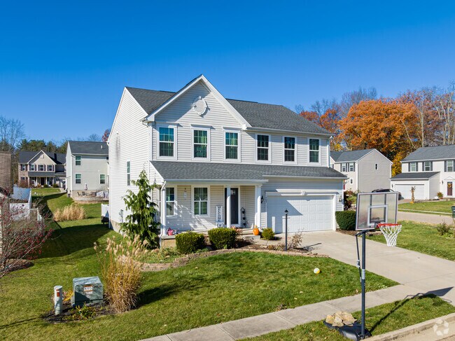 A portable basketball hoop sits outside this newly built two-story home in New England.