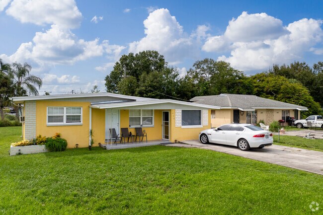 Homes in Belle vue display lush vegetation with tall palms and live oaks in many yards.