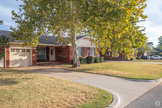 Brick ranch-style homes with mature trees are common in The Village.