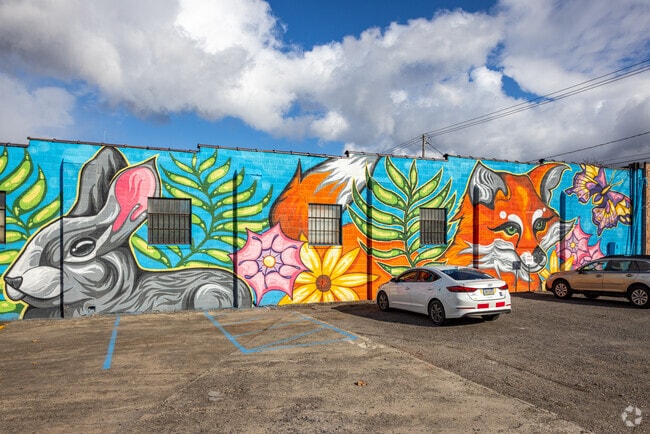 A colorful mural adorns the parking lot of a retail strip opposite the library in Wyoming, PA.
