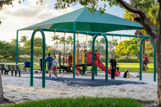 Families gather at the playground in West Kendale Lakes Park.
