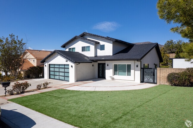 This modern Tujunga home has a green lawn and fenced backyard.