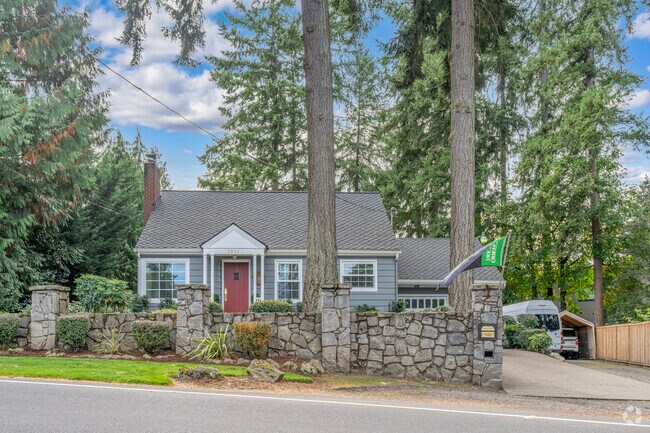 A classic bungalow in Blue Heron rests on a spacious wooded lot, blending cozy architecture with lush surroundings in Lake Oswego.