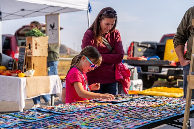 A little girl looks through some pins at the Brandon SD Farmers Market.