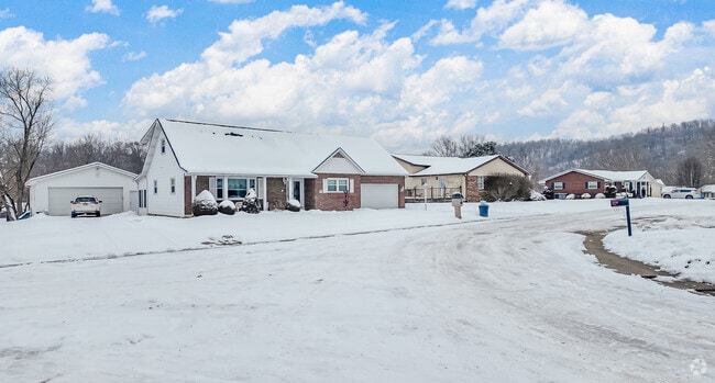 A snowy row of ranch style homes sits on a bend in the road, in Buffalo Creek.