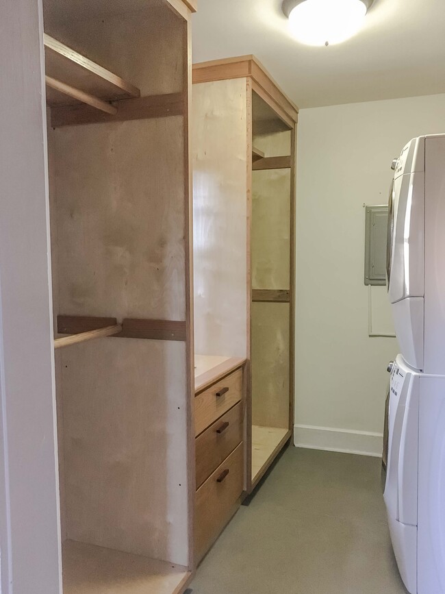 Walk in master closet with custom wood closets and drawers. Front loading washer and dryer.