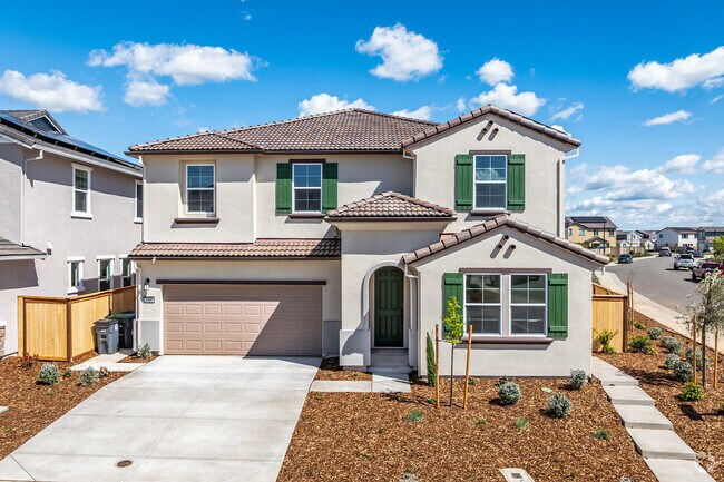 This Spanish style home has a tile roof, two-stories, and a 2-car garage in Montelena.