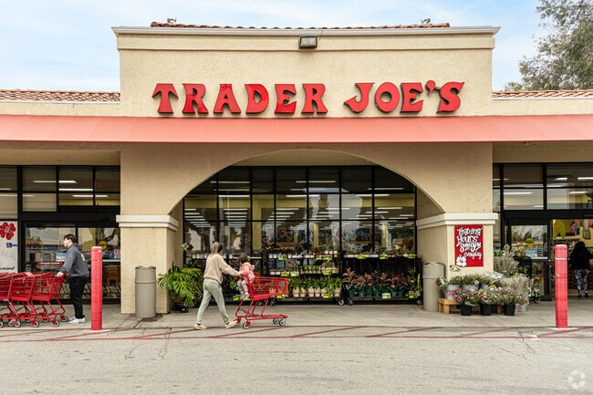 A customer walking in front of the flower display at the front of Trader Joes in Whittier.
